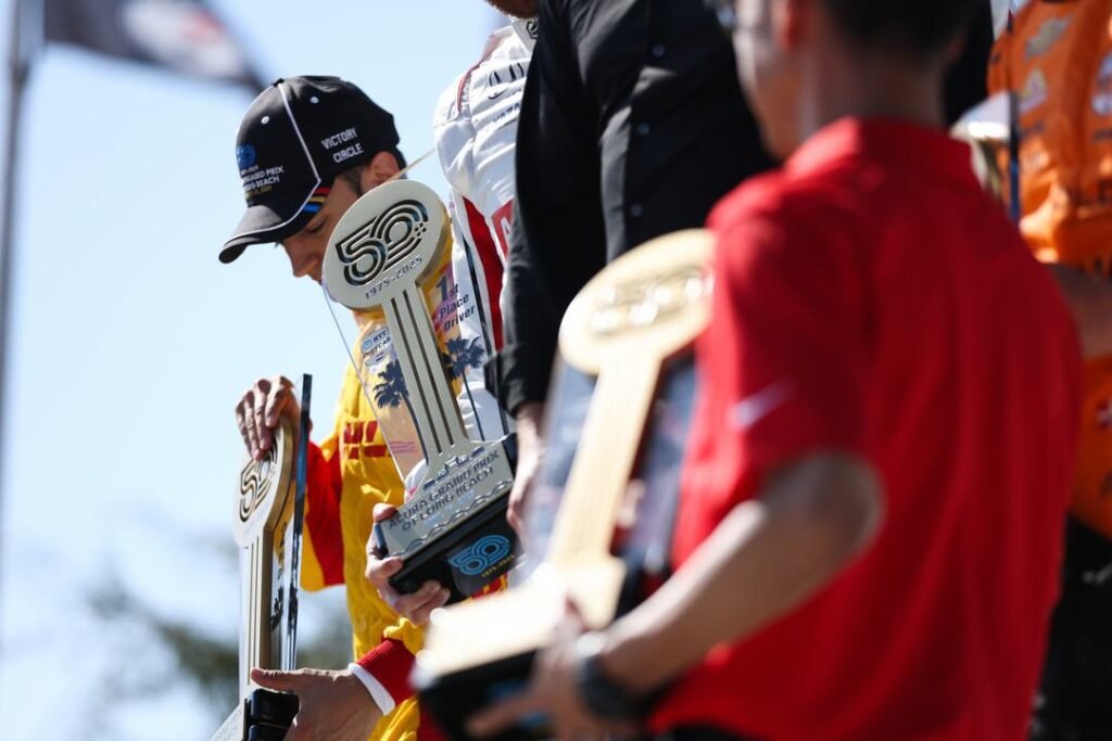 Kyle Kirkwood standing on the podium after the IndyCar Acura Long Beach GP