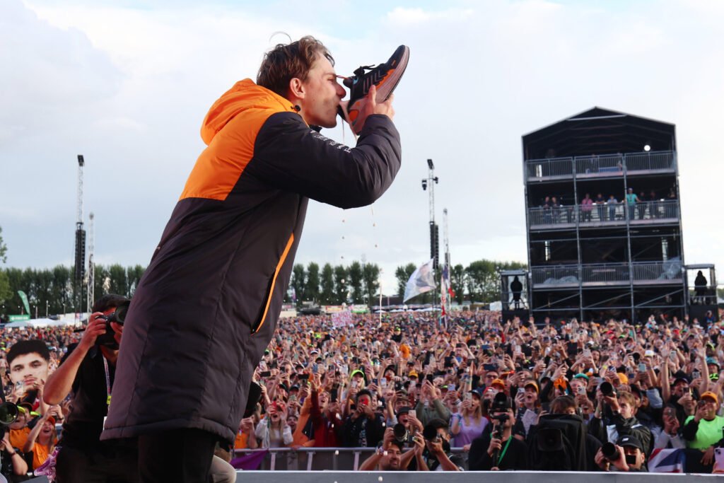 Oscar Piastri, McLaren F1 Team, performs a shoey on stage at the British GP